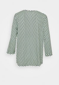 Multikleurige tuniek met een geometrisch patroon van zwarte en lichtgroene vormen. Lichtgewicht stof met een losse pasvorm en driekwartmouwen.