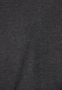 Dunkelgrauer, gestrickter Stoff mit glatter Textur. Die Oberfläche zeigt ein dezentes, gleichmäßiges Rippenmuster.