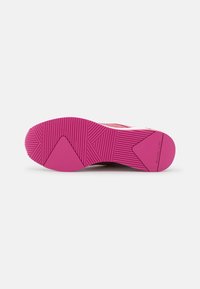 Suola della scarpa realizzata in un materiale gommoso fucsia, con scanalature testurizzate e un design della presa a motivi, evidenziando una forma angolare.