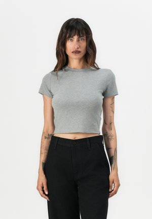 Pilkos spalvos trumpa t-shirt su trumpomis rankovėmis ir apvaliu kaklu, pagaminta iš minkštos medžiagos. Suderinta su aukštu liemeniu juodomis kelnėmis su mygtuko uždarymu.
