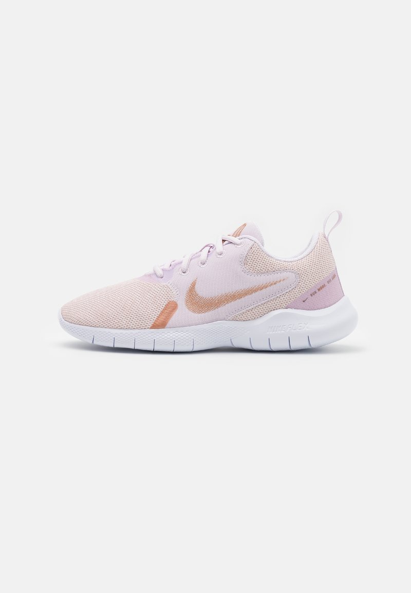 Chaussure de running Nike rose clair avec logo Swoosh en or rose, semelle blanche flexible et dessus en tissu mesh, vue de côté.