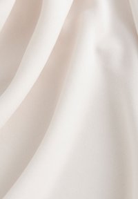 Tessuto beige chiaro con una texture morbida e liscia e un sottile motivo di trama, che si drappeggia in morbide pieghe. Ideale per abbigliamento o tappezzeria.