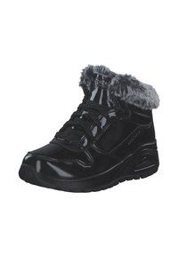 Bota de charol negro con un borde de pelaje sintético, puntera redonda, diseño de cordones y suela con amortiguación. Acentos texturizados en los laterales.