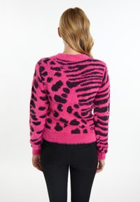 Maglione rosa fluffy con motivi di stampa animale nera e righe, con scollatura arrotondata e polsini e orlo a costine.
