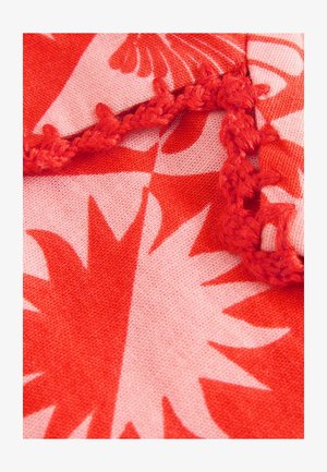 Tessuto di cotone con uno sfondo rosa e grandi motivi floreali rossi. Rifinito con dettagli in rosso a uncinetto lungo il bordo.