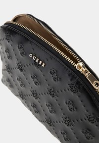 Black leather pouch with embossed floral pattern, gold-tone zipper, and brand logo. Smooth texture and rounded design.