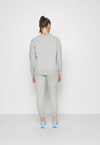 Under Armour RIVAL FLEECE - Pantaloni sportivi - mod gray light heather/white