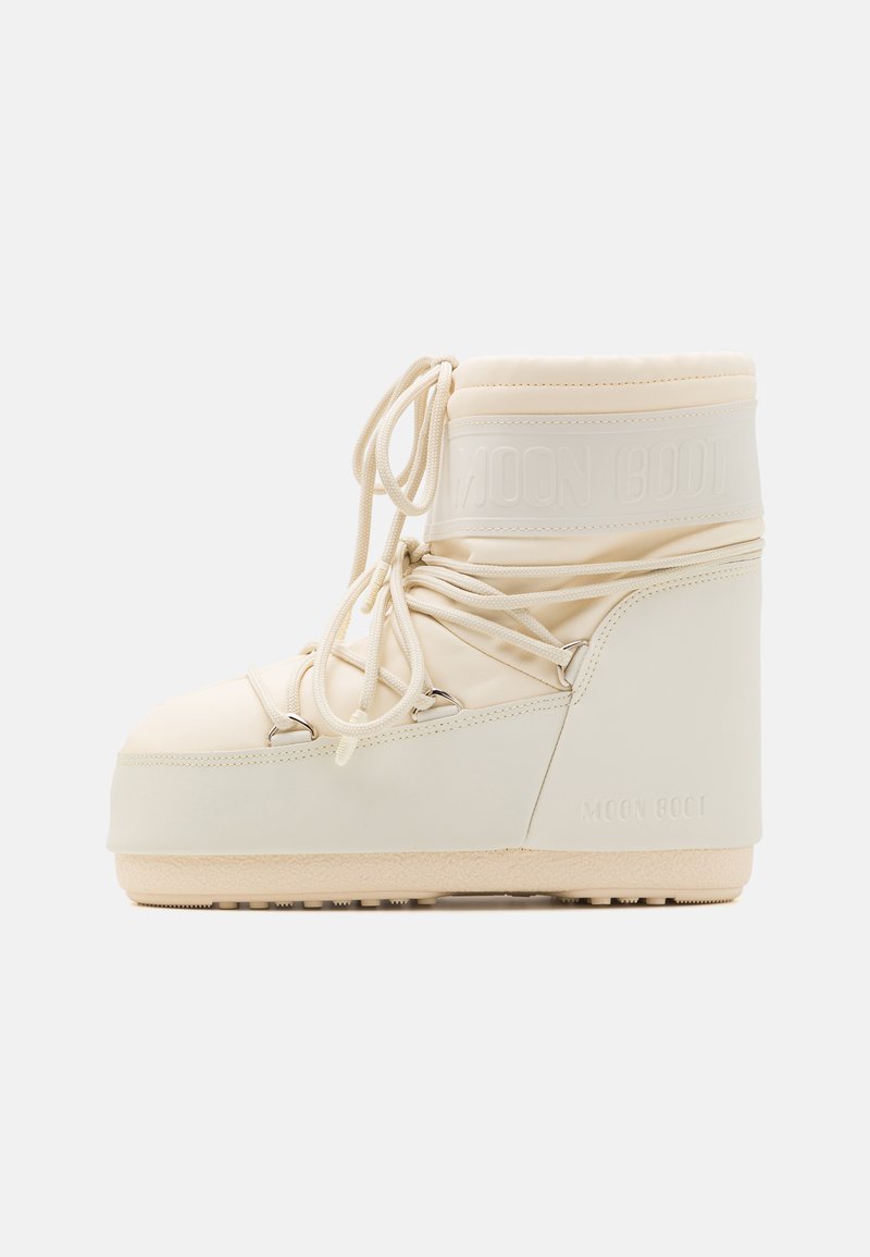 Krämfärgad Moon Boot med vadderad skaft, snörning framtill och texturerad gummisula. Har en logotyp på ovansidan och en kraftig form.