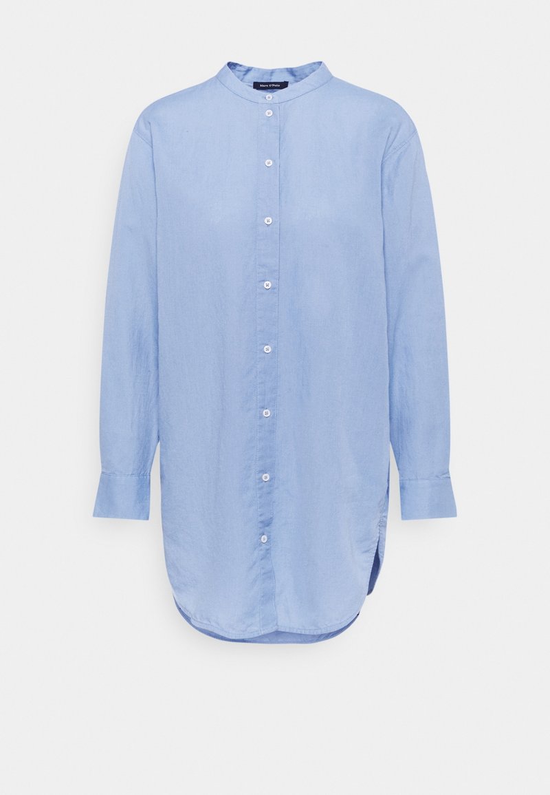 Chemise bleu clair à manches longues en tissu doux, avec un col mao, une fermeture boutonnée sur le devant et un ourlet arrondi.