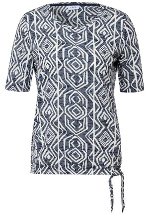 Top de manga corta en azul marino y blanco con patrones geométricos, un escote redondo y un detalle atado en el dobladillo. Tejido suave y texturizado.