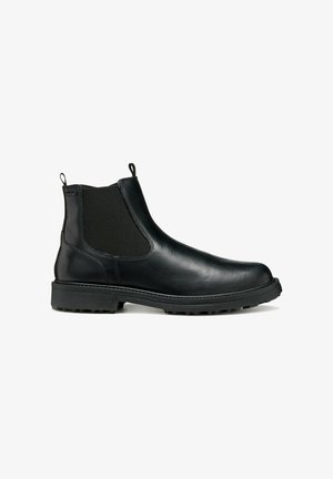 Bottine Chelsea en cuir noir avec panneaux élastiques sur les côtés, languettes de tirage et semelle en caoutchouc texturé pour une bonne adhérence. Fini lisse, design minimaliste.