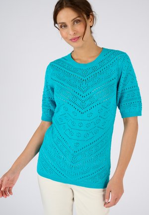 Maglione turchese lavorato a maglia con maniche corte, caratterizzato da un motivo a zigzag e da un design a punto aperto, completato da un collo e un orlo a coste.