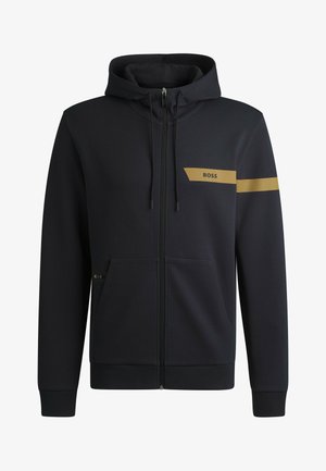 Schwarze Zip-Up-Hoodie aus glattem Stoff. Mit goldenem Logo auf der linken Brust und Streifen am Ärmel. Verfügt über Fronttaschen und eine Kapuze mit Kordelzug.