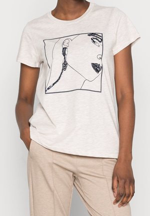 Kvinde iført en hvid kortærmet T-shirt med et minimalistisk sort linjemaleri af et ansigt og sorte pailletter i detaljer på læber, øreringe og øje.