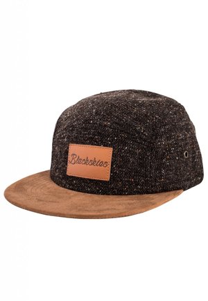 Black cap made of textured dark fabric with a light brown leather peak and patch. Features a logo embossed on the leather patch.