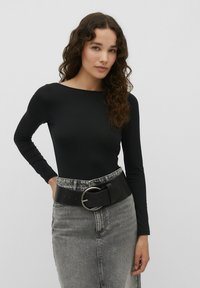 Schwarzer langärmeliger Bodysuit mit Rundhalsausschnitt, kombiniert mit einem grauen Denimrock und einem breiten schwarzen Gürtel mit einer silbernen runden Schnalle.