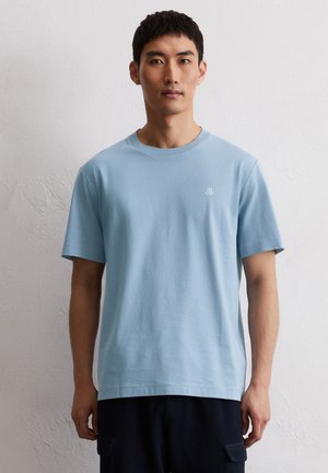 Lichtblauwe katoenen T-shirt met een ronde halslijn. Beschikt over korte mouwen en een klein wit logo op de linkerborst. Eenvoudig ontwerp, regular fit.