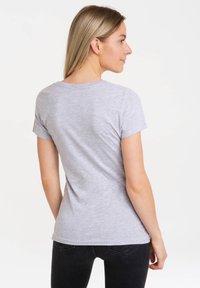 Light gray cotton t-shirt with short sleeves, a rounded neckline, and a fitted silhouette, paired with black jeans.