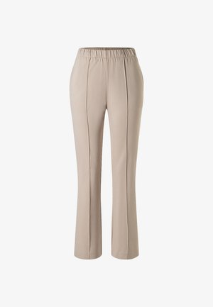 Beżowe spodnie o prostych nogawkach z elastycznym pasem i przednimi plisami, zaprojektowane do noszenia na co dzień lub do pracy.