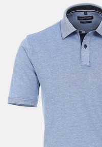 Ljusblå pikétröja i stretchmaterial. Har en kontrasterande strukturerad krage och en placket med två knappar samt en svart knapp.