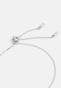 Verstellbare Silbernketten mit einer dünnen Kette. Enthält eine sphärische Perle und zwei Metallenden auf jeder Seite. Reflexive Oberfläche.