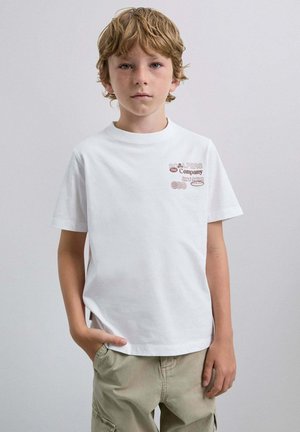 Camiseta de algodón blanca con cuello redondo y mangas cortas, que presenta un estampado gráfico marrón en el área del lado izquierdo del pecho. Diseño simple sin patrones.