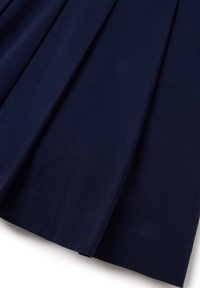 Falda plisada de color azul marino hecha de tela texturizada. Presenta pliegues profundos y un acabado suave en el dobladillo, asegurando una caída estructurada.