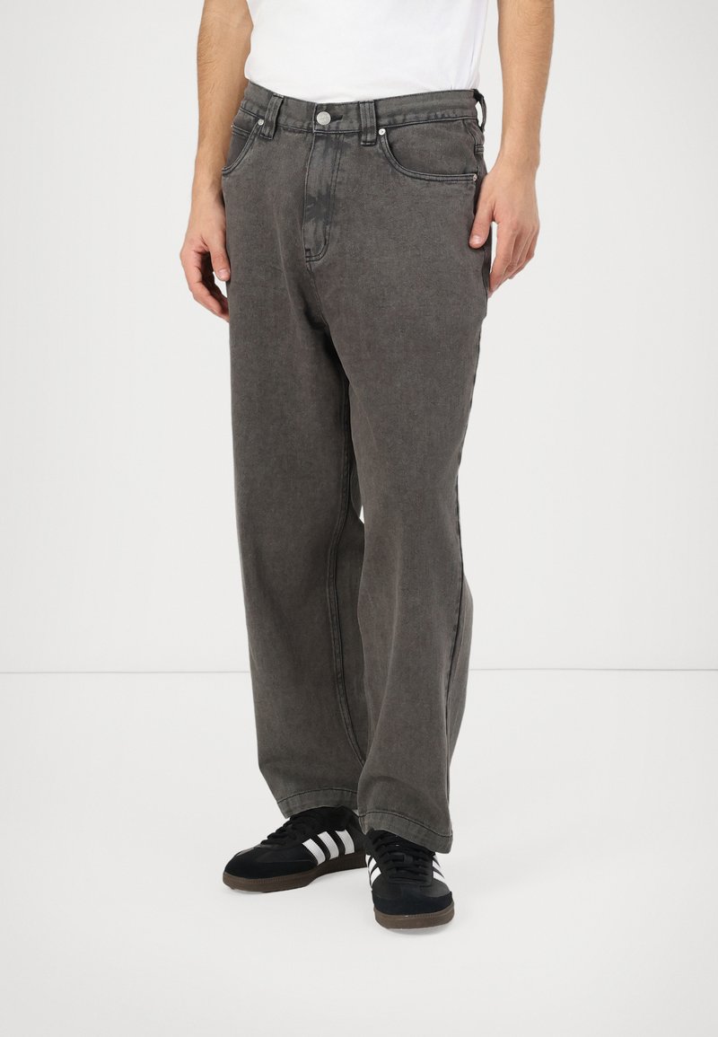 Grijze denimbroek met een ontspannen pasvorm, voorzien van vijf zakken, contrasterende stiksels en een knoopsluiting bij de taille.