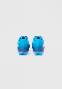 Μπλε ποδοσφαιρικά παπούτσια με διαβαθμισμένο σχέδιο, κομψό σχήμα, υφή στην επιφάνεια και σχέδιο με εξαγωνικά ελαστικά σε ανοιχτότερη μπλε απόχρωση.