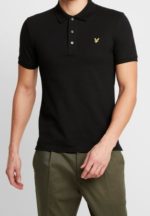 Schwarzes Poloshirt mit kurzen Ärmeln, dreiknöpfiger Blende und einem kleinen gelben Adlerlogo auf der linken Brust. Aus weichem Stoff gefertigt.