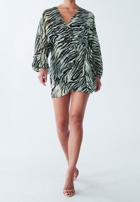 Eläinkuosiinen kietaisumekko vaaleanvihreänä ja mustana, jossa pitkät pussihihat ja vyötärönauha. Kevyt, läpikuultava kangas.