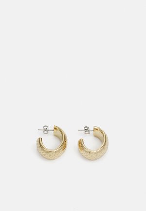 Pendientes de aro de oro con una superficie texturizada y un acabado pulido. Diseñados en forma circular con un cierre de soporte seguro.