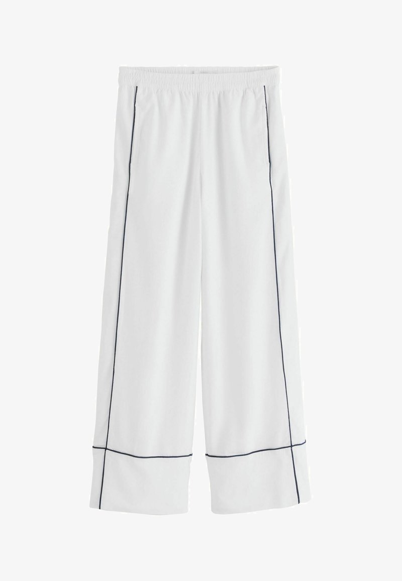 Pantalon blanc à jambes larges avec taille élastique et passepoil noir contrastant le long des coutures latérales et près de l'ourlet.