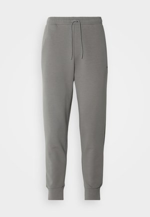 Pantalon de jogging gris en tissu doux, avec une taille élastique à cordon de serrage et des poignets côtelés aux chevilles.