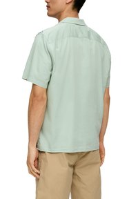 Korte mouw shirt in licht mintgroene stof, met een gladde textuur, een rugpand en een ontspannen pasvorm. Geen zichtbare patronen of accenten.