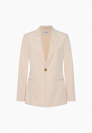 Kremfarvet dameblazer med lange ærmer, enkelt brunt knaplukning, slag med udskæring og to forlommer med slidser.