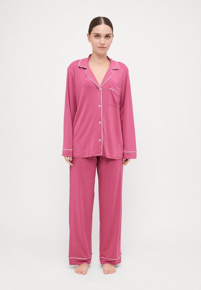 Set di pigiama rosa con maniche lunghe e pantaloni, dotato di colletto a scollo a V, chiusura a bottoni, tasca e dettagli in piping bianco a contrasto.