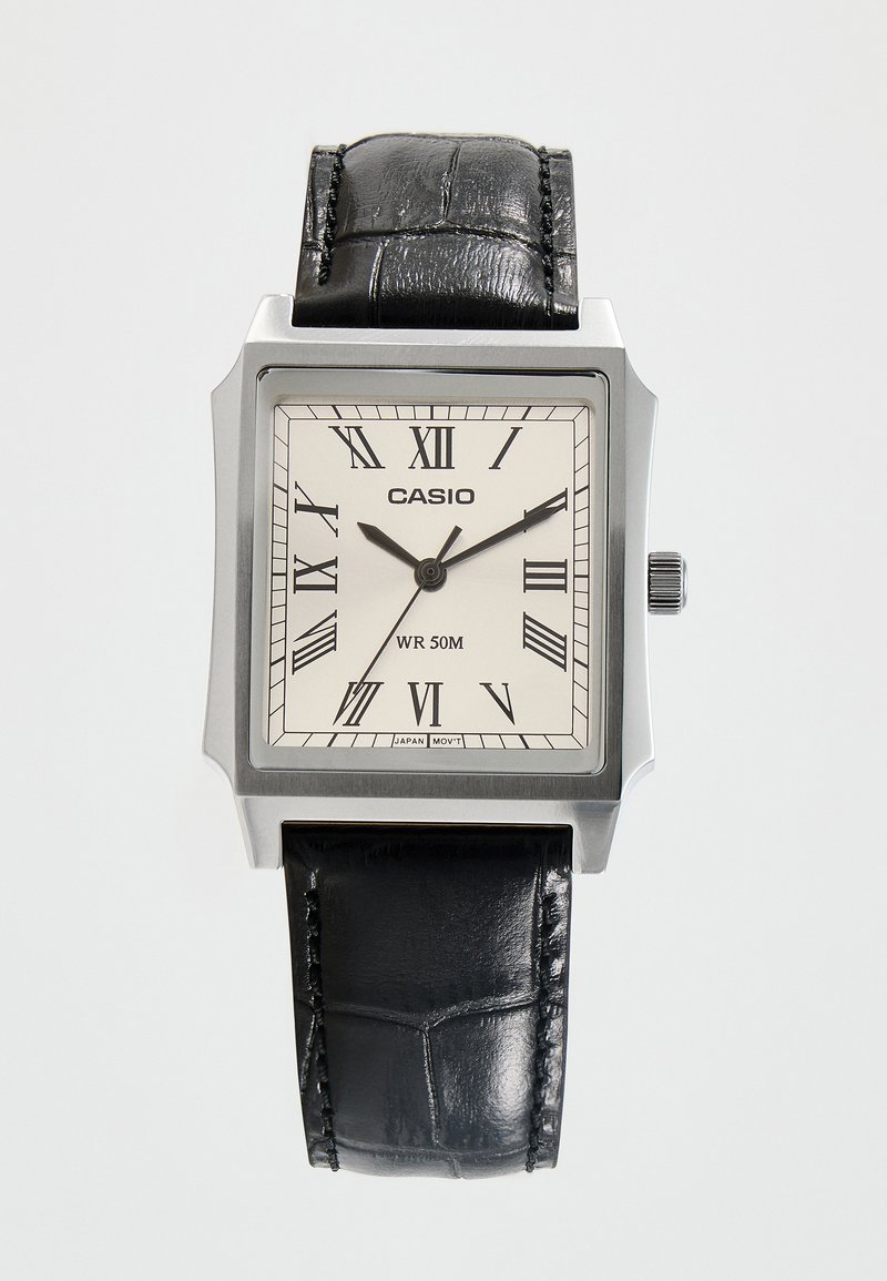 Montre-bracelet carrée argentée Casio avec bracelet en cuir noir, cadran blanc, chiffres romains, et aiguilles des heures, minutes et secondes indiquant 10:09:36.