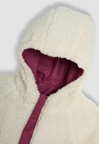 Vit fleecehuva med en texturerad yta och ett vinrött foder, utrustad med huva och framfjädring.