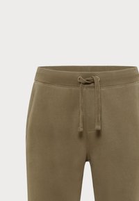 Olivengrønne joggerbukser med en blød tekstur, elastisk talje og snorelukning. Enkelt design uden yderligere mønstre eller detaljer.