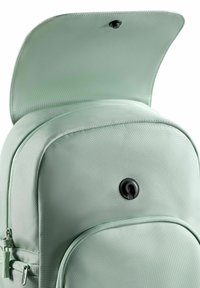 Sac à dos vert menthe en tissu texturé, avec un grand compartiment zippé et un fermoir à pression noir sur le rabat supérieur. Comprend une poche frontale.