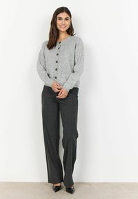 Cardigan butonat de culoare gri deschis, cu decolteu rotund, asortat cu pantaloni texturați de culoare gri închis și tocuri negre cu vârful ascuțit. Material tricotat neted.