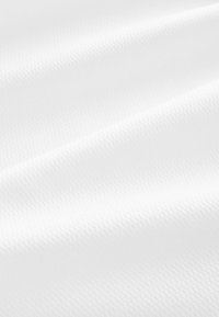 Gros plan d'un tissu blanc lisse avec de subtiles ondulations diagonales et une fine texture tissée.