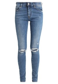 Jeans ajustados de denim azul claro con detalles desgastados y rasgados en las rodillas y una textura suave. Diseño clásico de cinco bolsillos con cierre de botón.