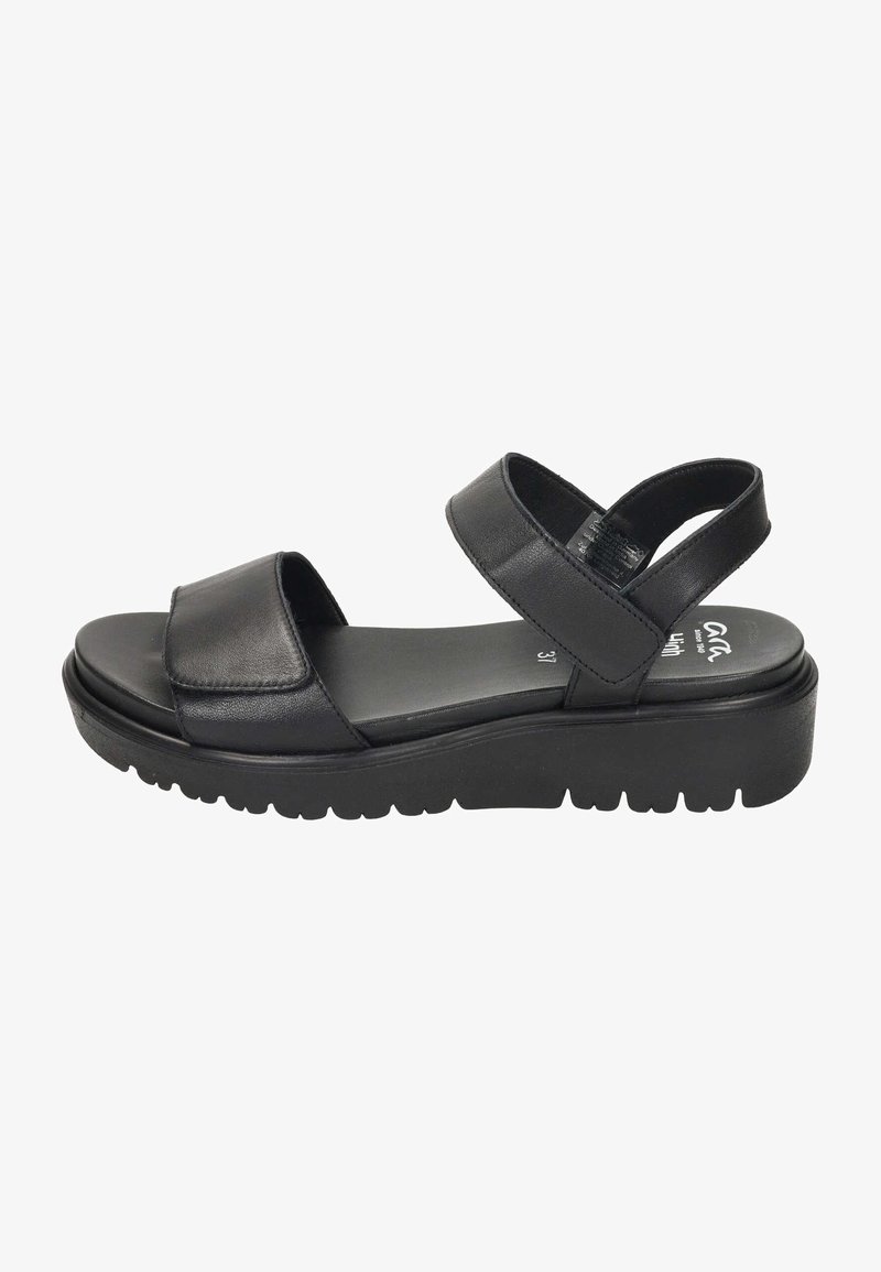 Sandale en cuir noir avec semelle épaisse, brides avant et à la cheville réglables, et talon compensé bas pour le confort et le maintien.