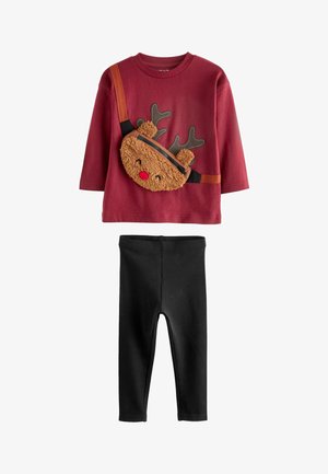 Bordó hosszú ujjú póló rénszarvas mintával, fekete bordázott nadrág és barna plüss keresztpántos táska. Fekete sportcipő, barna talppal.