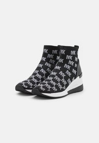 Schwarz-weiße High-Top-Wedgesneaker mit einem gestrickten Obermaterial, das mit sich wiederholenden "MK"-Logomustern bedeckt ist.
