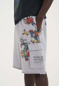 Gray shorts made of cotton blend feature colorful dragon designs, side pocket with flap, and "DON ED HARDY designs" printed at the hem.