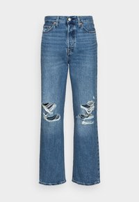 Vaqueros de denim azul con un diseño de pierna recta, que presentan dos grandes desgarros en las rodillas, costuras visibles y un cierre clásico de botón.