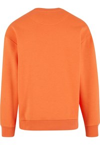 Oransje genser med rund hals, lange ermer, ribbestrikkede mansjetter og en myk, jevn tekstur. Ingen synlige mønstre eller logoer.